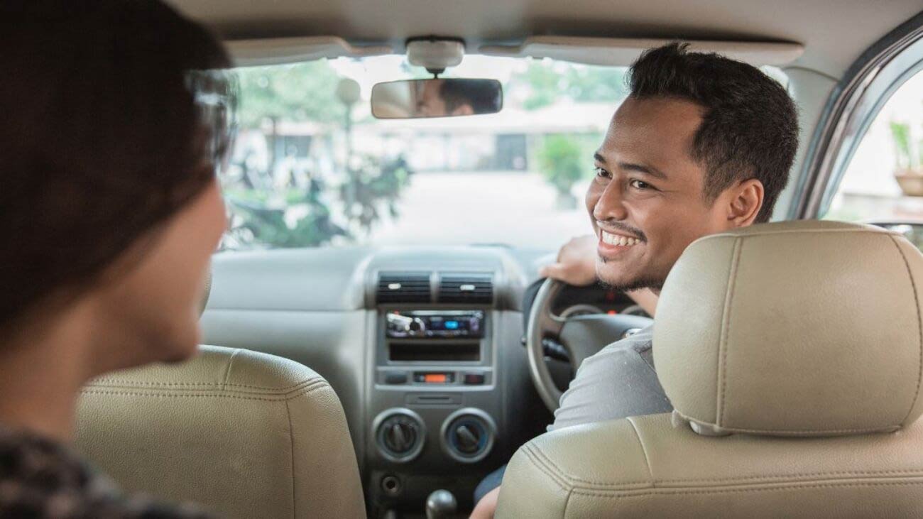 Rideshare driver looking at passenger in back seat