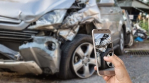 Hand of woman holding smartphone and take photo of car accident