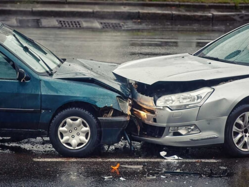 Car accident on wet road during rain, head on collision side view.